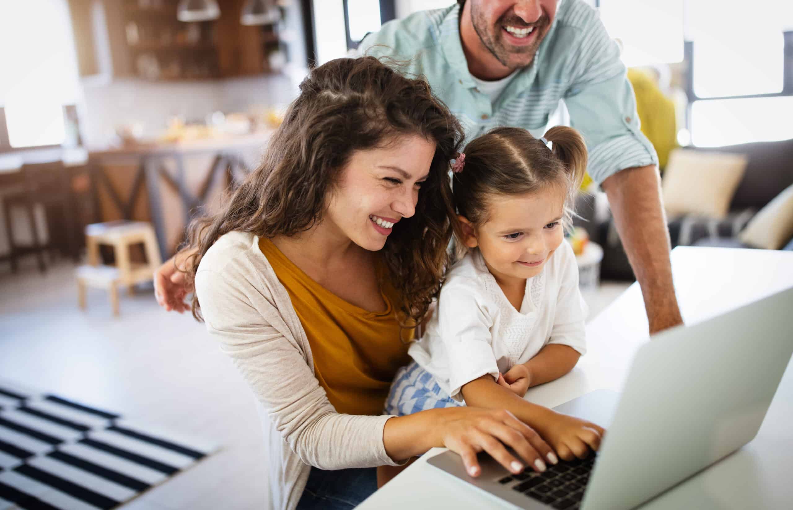 Happy family spending time at home and using laptop